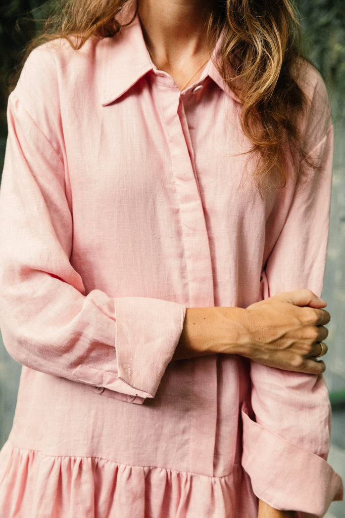Woman wearing the classic linen drop waist dress in dusty pink