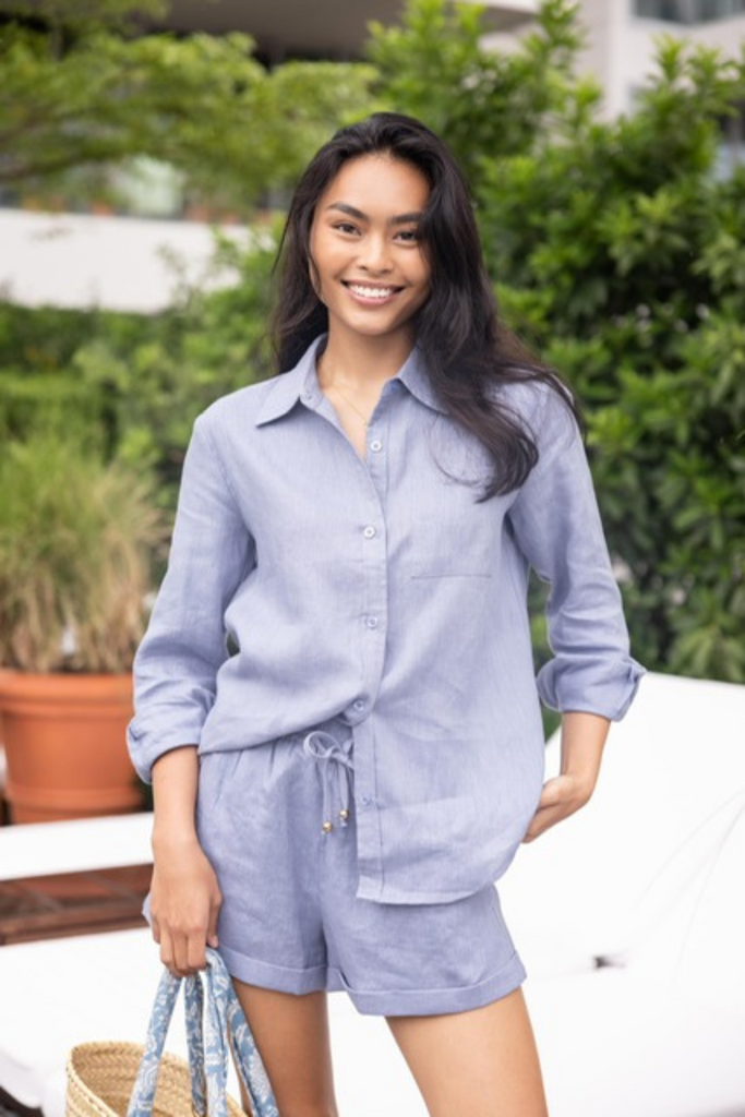Woman wearing the classic linen shorts in chambray blue