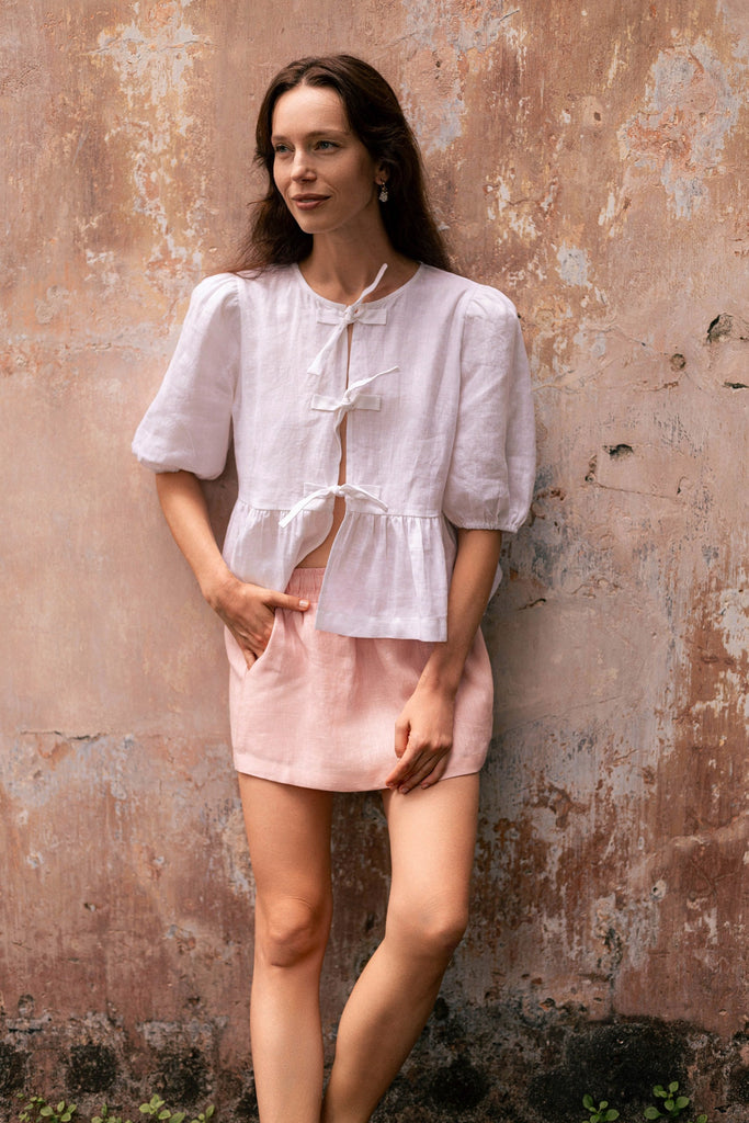 Woman wearing summery the label's classic linen skirt in dusty pink