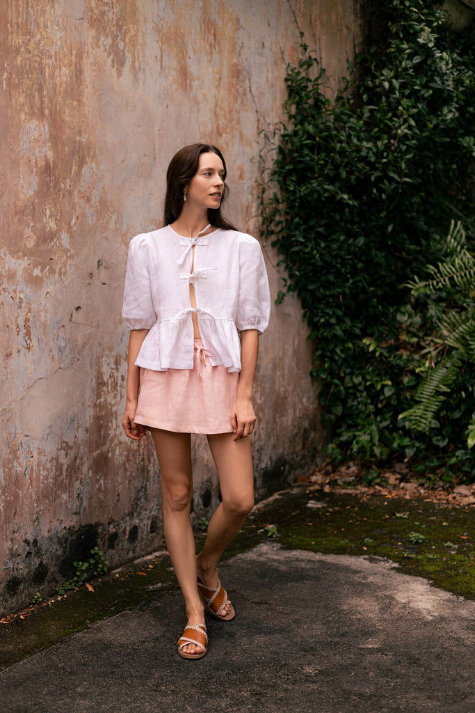 Woman wearing summery the label's classic linen skirt in dusty pink