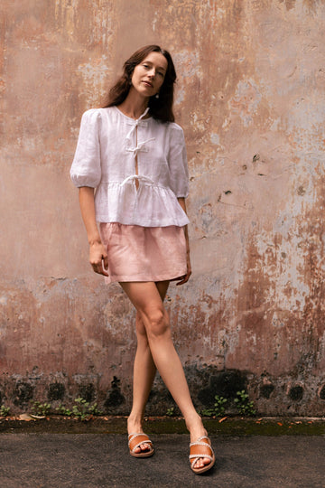 Woman wearing summery the label's classic linen skirt in dusty pink