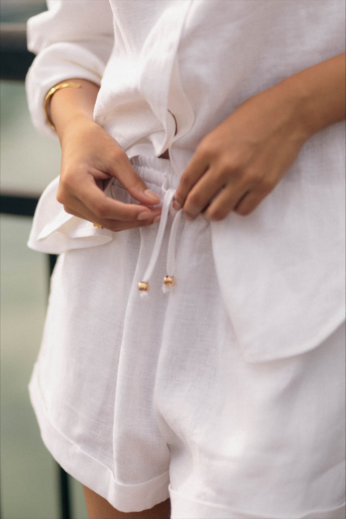 Woman wearing the classic linen shorts in white